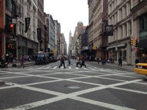 People crossing the street within a crosswalk in New York City