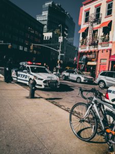 Police car flashing its lights while parked on the street in a busy area