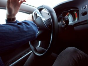 A person turning the steering wheel of a vehicle upside down