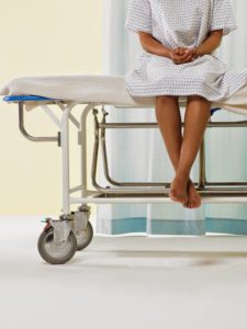 A female patient sitting on a medical bed