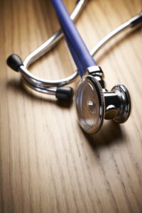 Stethoscope laying on a wood table