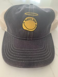 A baseball cap with a yellow Happy Jack logo on the front
