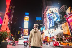 A person standing in the middle of a busy downtown area