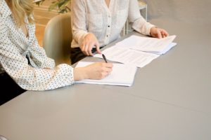 Two people sitting at a table and going over documents