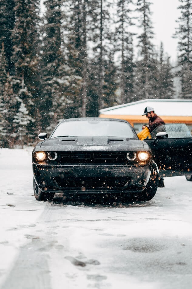 Person entering a car in snowy conditions