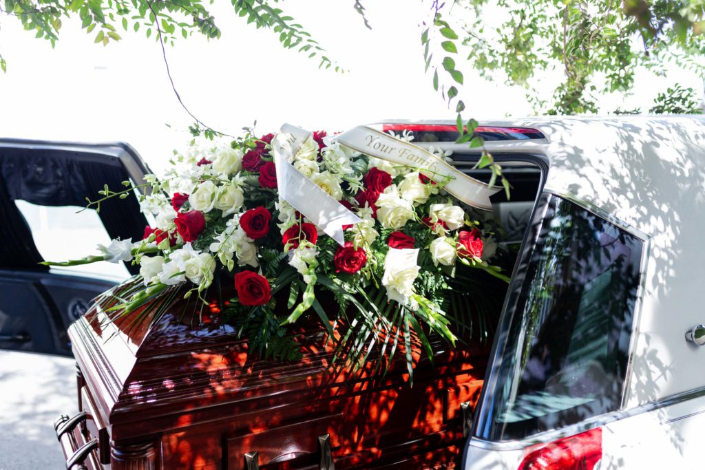 A casket being put into a hearse