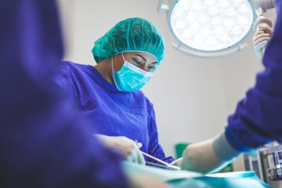 A medical professional doing surgery on a patient