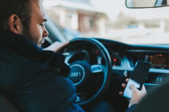 A person looking at their phone while driving