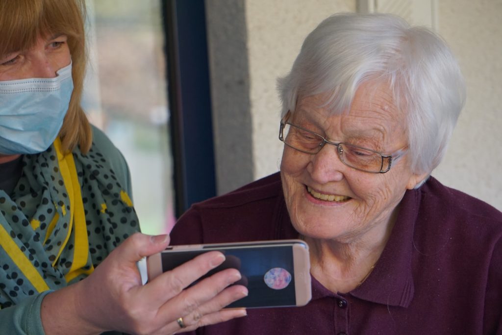 An older woman viewing something on a smartphone