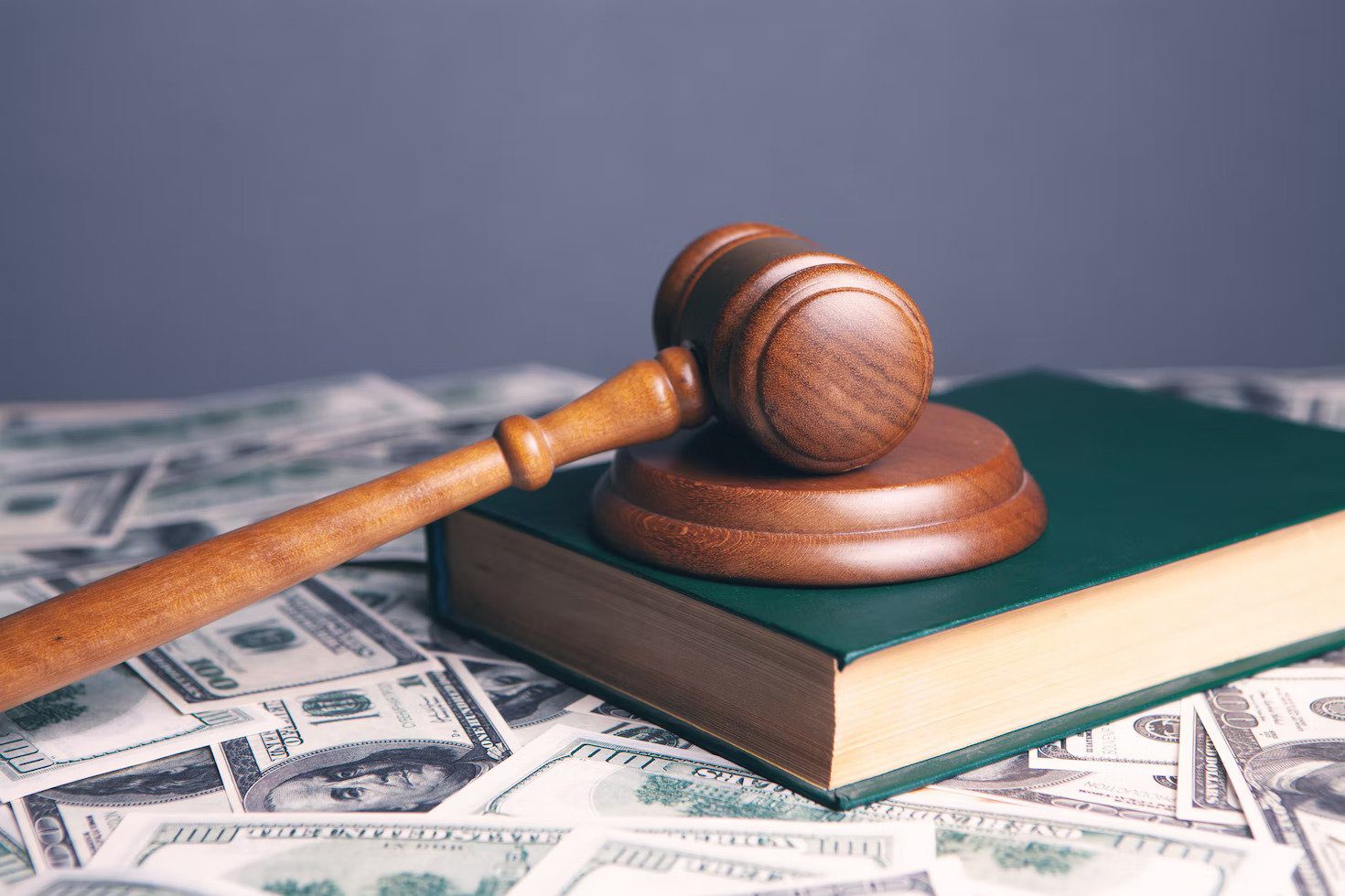 Gavel atop a book, atop a pile of money