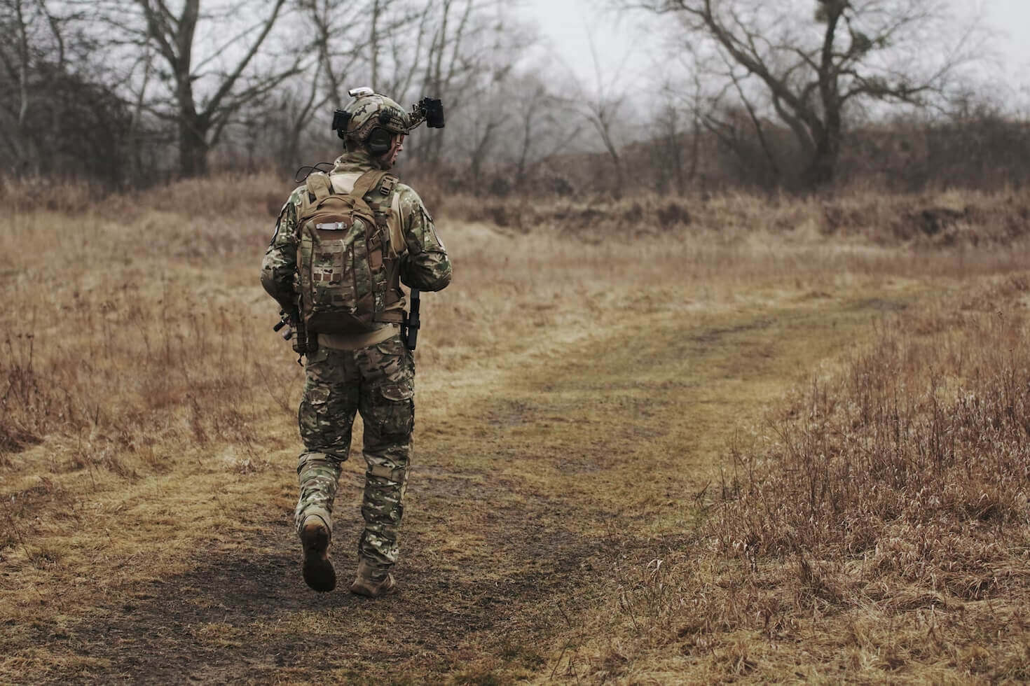 Military member walking through a field
