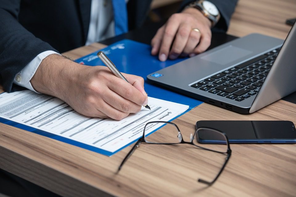 Lawyer filling out forms and working on laptop